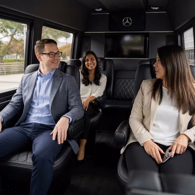 Group boarding a white charter bus for Corporate Transportation transportation in Jacksonville