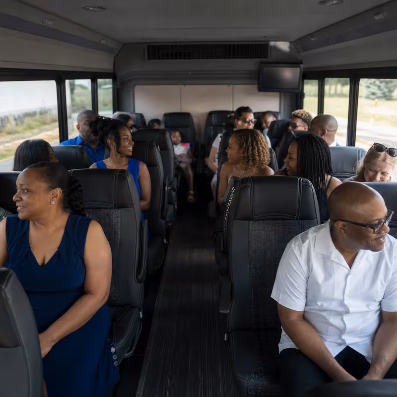 Group boarding a white charter bus for Private Event Transportation transportation in Jacksonville