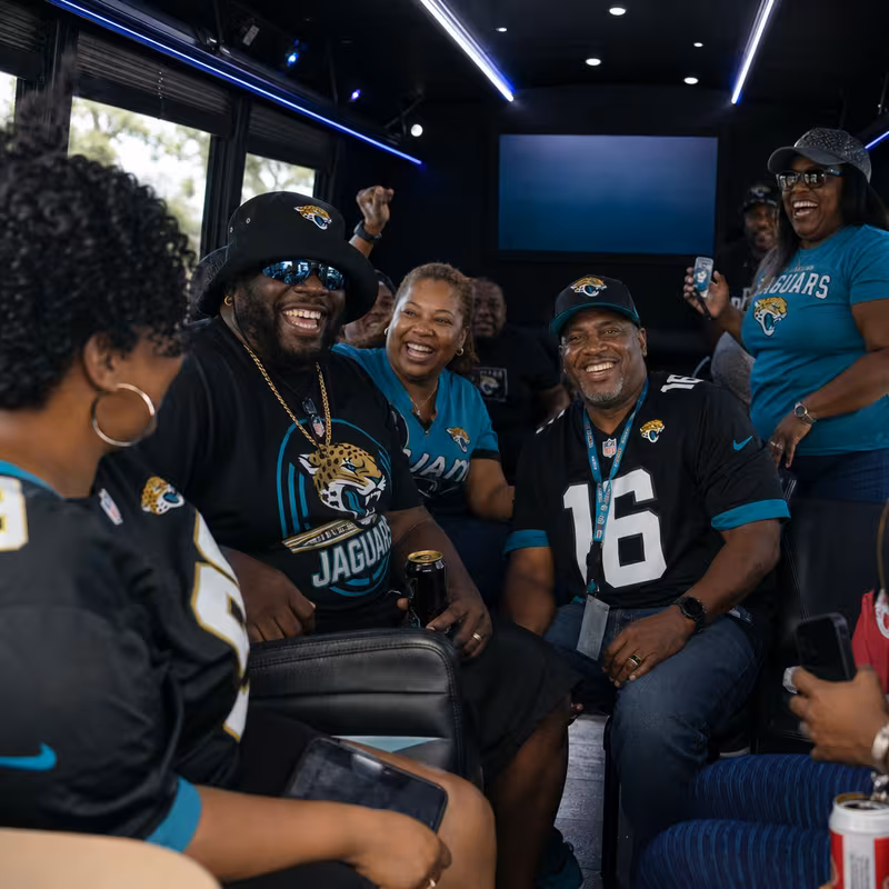 Group boarding a white charter bus for Sporting Event Transportation transportation in Jacksonville